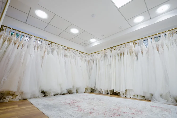 Designer-Brautkleider an goldenen Kleiderstangen im Showroom